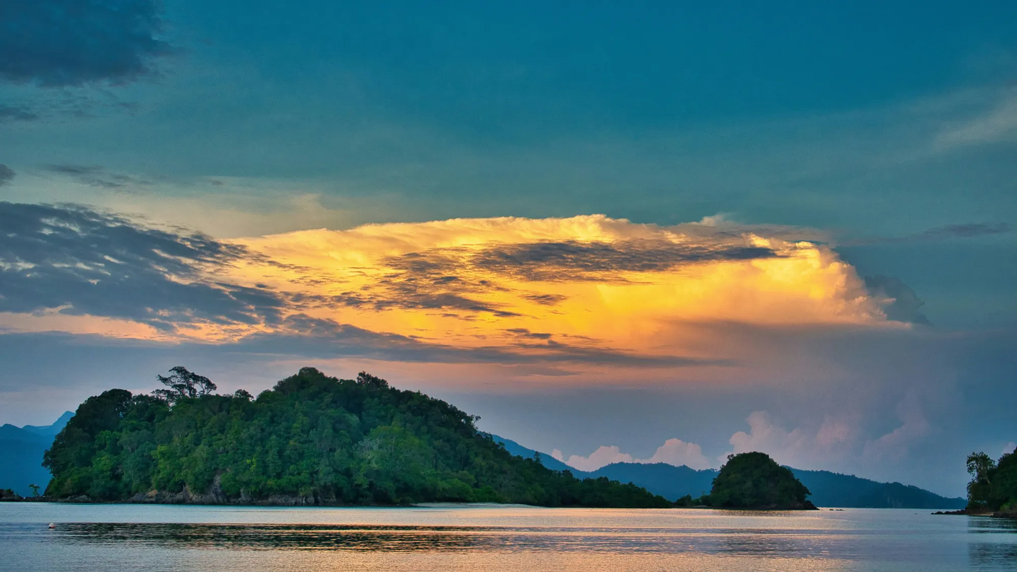 A green island under a glowing sunset sky off the coast of Langkawi