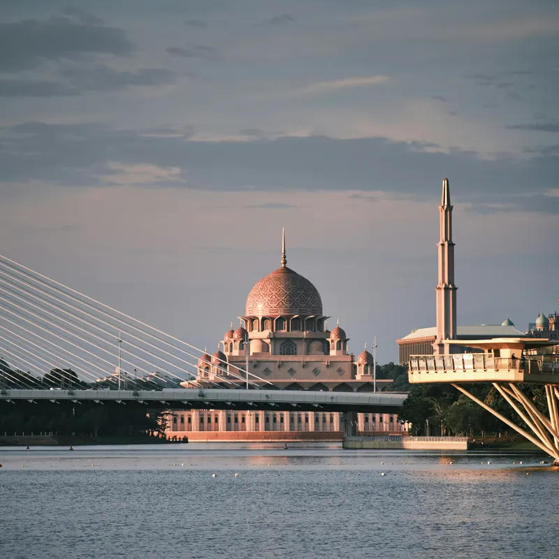 The pink-domed Putra Mosque beside the lake in Putrajaya at dusk